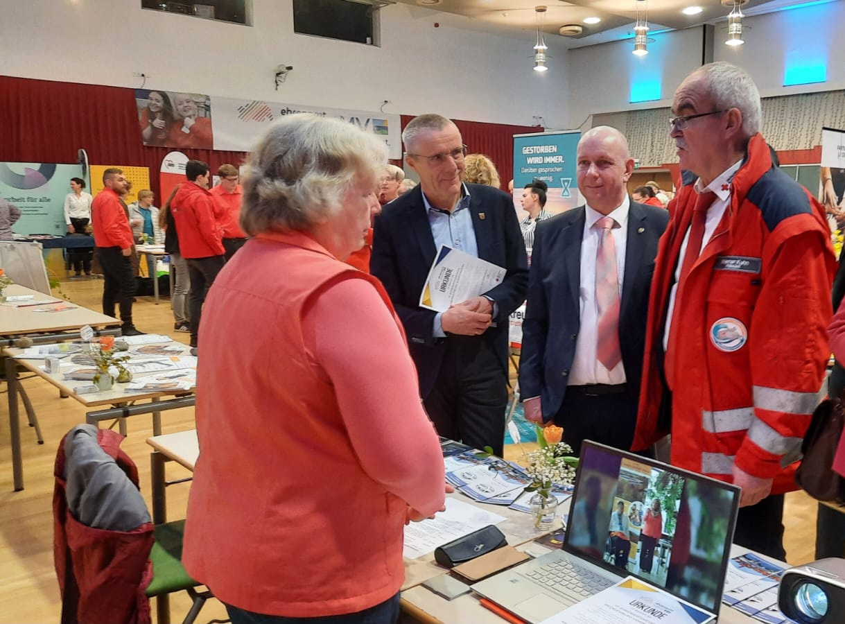 Interessierte Personen am Messestand, um sich zu informieren.