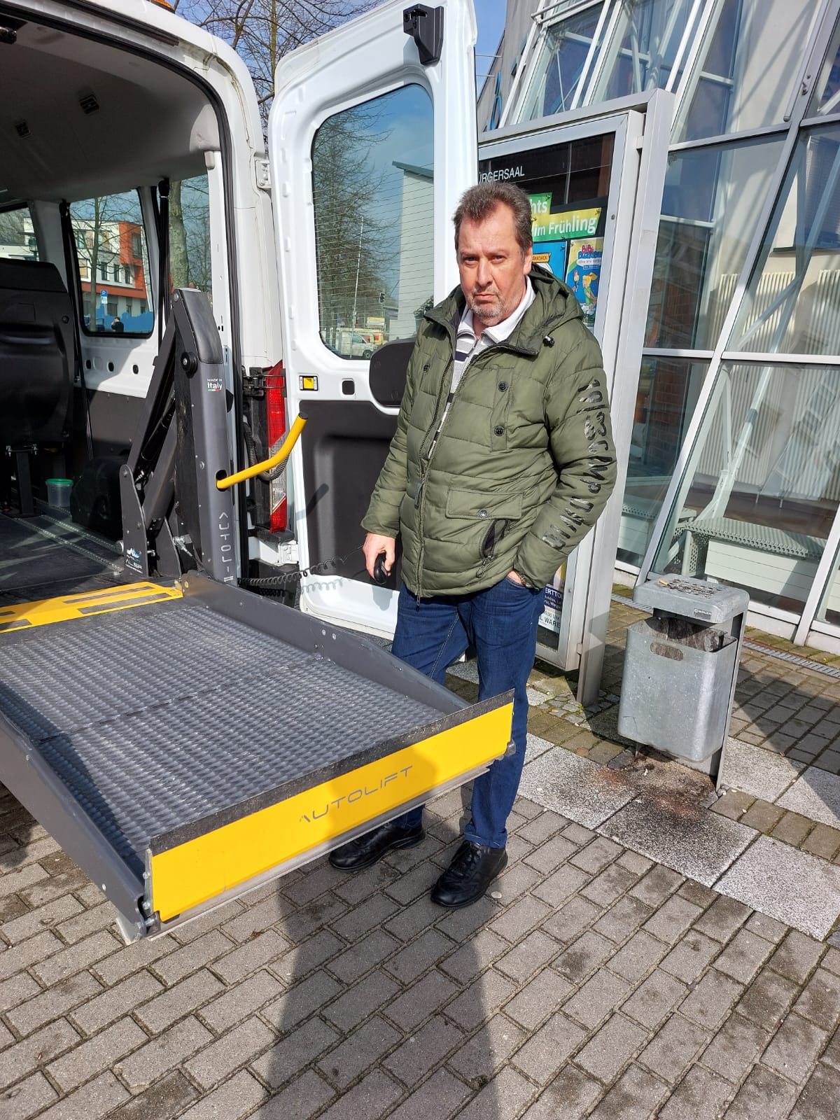 Busfahrer präsentiert einen modernen Kleinbus mit Lift
