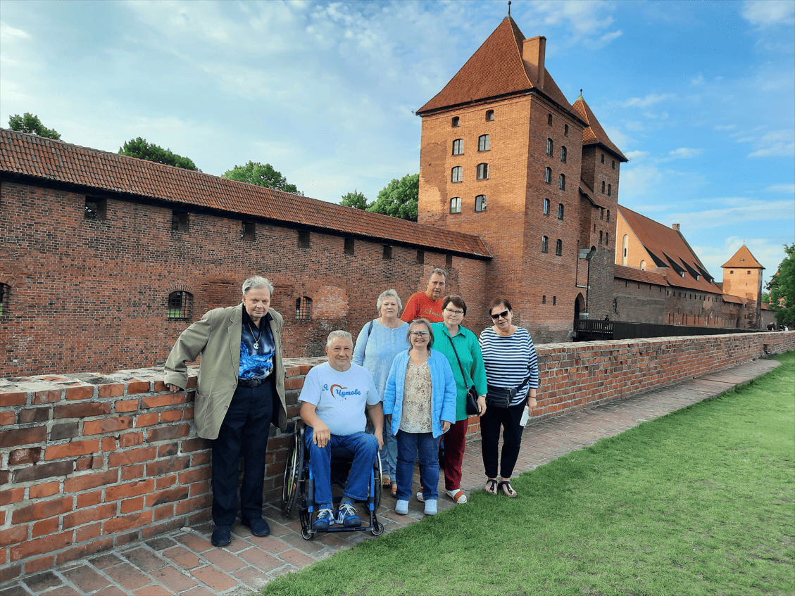 Reisegruppe vor alter Burg